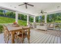 Covered back porch featuring a dining table, seating area, and ceiling fans, ideal for outdoor living at 110 White Oak Trl, Cumming, GA 30028