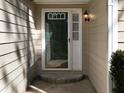 Exterior close-up of front door and entryway, featuring a light fixture and stone step at 1234 W Wylie Bridge Rd, Woodstock, GA 30188