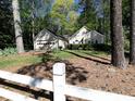 View of a home with a white picket fence and mature trees at 1234 W Wylie Bridge Rd, Woodstock, GA 30188