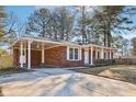 Side view of a brick home with a covered carport and manicured landscaping at 8298 Holly Dr, Jonesboro, GA 30238