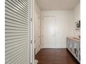 Hallway featuring wood floors, white doors, closet with louvered doors, and a decorative cabinet at 1065 Peachtree Ne St # 2803, Atlanta, GA 30309