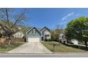 Charming two-story home featuring stone accents, vinyl siding, large driveway, and well-manicured lawn at 1015 Pebble Creek Trl, Suwanee, GA 30024