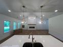 Open concept living space showcases the kitchen and living room with an elegant chandelier and fireplace at 500 Level Creek Rd, Sugar Hill, GA 30518