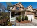 Inviting home with a charming front porch, manicured bushes, and a two-car garage at 3482 Willow Meadow Ln, Douglasville, GA 30135