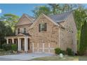 Charming two-story brick home featuring a welcoming front porch, a well-manicured yard, and a two car garage at 358 Nature Brook Se Walk, Smyrna, GA 30082