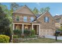 Charming two-story brick home featuring a welcoming front porch and a well-manicured front yard with beautiful landscaping at 358 Nature Brook Se Walk, Smyrna, GA 30082
