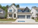 Lovely two-story home with a brick facade, gray siding, and a two-car garage at 461 Maypop Ln, Woodstock, GA 30188