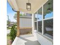 Inviting front porch with wooden railing and a modern pendant light fixture at 461 Maypop Ln, Woodstock, GA 30188