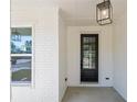 Charming front porch with brick columns and a modern pendant light fixture at 461 Maypop Ln, Woodstock, GA 30188