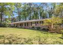 Beautifully landscaped front yard of brick home, showcasing lush green lawn and colorful flower beds at 504 Baltimore Sw Ave, Lilburn, GA 30047