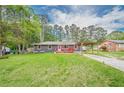 Full front exterior view of a charming house with well-maintained landscaping and carport at 846 Orris Ln, Mableton, GA 30126