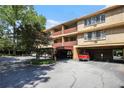 Multi-story condo building with covered parking, balconies, and mature trees in a lush neighborhood at 2637 Peachtree Ne Rd # 407, Atlanta, GA 30305