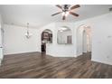 Bright living room featuring dark hardwood floors, white walls, and elegant archway transitions at 3095 Bonnes Dr, Lithonia, GA 30038
