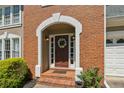Inviting front entrance with a brick archway, classic wood door with wreath, and sidelights at 3362 Timber Rdg, Powder Springs, GA 30127