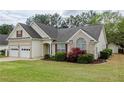 Beautiful home with a well-maintained lawn, two-car garage, and complemented by lush landscaping at 854 Nichols Landing Ln, Dacula, GA 30019