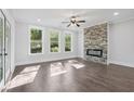 Sunlit living room featuring a stone accent wall with fireplace and gleaming hardwood floors at 1002 Coleman Sw St, Atlanta, GA 30310