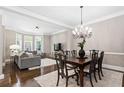 Open-concept living and dining area featuring hardwood floors, neutral paint, and large windows offering natural light at 3105 Neal Ct, Cumming, GA 30041