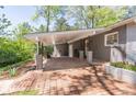 Attached carport of a gray brick home with brick floor at 3860 Carlton Dr, Atlanta, GA 30341