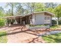 Charming gray brick home with brick walkway, flowerbed, and attached carport at 3860 Carlton Dr, Atlanta, GA 30341