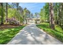 Inviting home with a long driveway surrounded by mature trees and lush greenery at 1855 Mountain Trce, Canton, GA 30114
