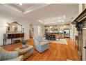 Open-concept living space with a fireplace, kitchen, and dining area with elegant hardwood floors and recessed lighting at 2550 Ballantrae Cir, Cumming, GA 30041