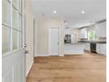 Bright entryway and view of the modern kitchen with white cabinets, granite countertops, and stainless appliances at 5224 W Mountain St, Stone Mountain, GA 30083