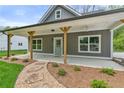 Inviting covered porch with wood beams and stone walkway adding charm to this craftsman-style home at 5224 W Mountain St, Stone Mountain, GA 30083