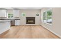 Open-concept living area featuring a modern fireplace, bright windows, and wood flooring throughout at 5224 W Mountain St, Stone Mountain, GA 30083