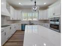 Modern kitchen with white cabinets, stainless steel appliances, and a large center island at 5567 Tyree Rd, Winston, GA 30187