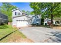Two-story home with a two-car garage and a wide driveway lined with well-manicured lawn and mature trees at 206 Cole Ct, Canton, GA 30114