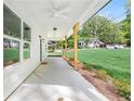 Covered front porch with ceiling fans, wood columns and a view of the front lawn at 5232 W Mountain St, Stone Mountain, GA 30083