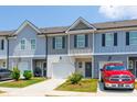 Attractive townhomes with garages, well-kept lawns, and colorful landscaping create a welcoming exterior at 7144 Gladstone Cir, Stonecrest, GA 30038