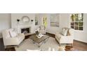 Bright living room with a decorative fireplace, hardwood floors, and large windows allowing ample natural light at 4477 Jett Nw Rd, Atlanta, GA 30327