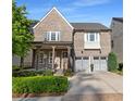Charming two-story brick home featuring a covered front porch and a two-car garage with updated doors at 6454 Meridian Way, Atlanta, GA 30328