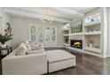 Cozy living room showcasing a modern fireplace, elegant built-ins, and hardwood floors at 823 Canterbury Overlook, Atlanta, GA 30324