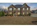 Beautiful brick home with a manicured lawn, mature trees and gray roof at 4580 Cloister Cir, Hampton, GA 30228