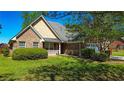 Attractive brick home featuring a cozy front porch, manicured bushes, and a well-kept lawn at 925 Wynn Rd, Mcdonough, GA 30252