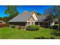 Beautiful brick home with lush green lawn and well-maintained landscaping, showcasing the property's curb appeal at 925 Wynn Rd, Mcdonough, GA 30252