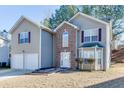 Charming two-story home with a two-car garage and brick entryway and well maintained lawn at 4089 Palm Dr, Snellville, GA 30039