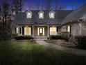 Inviting brick home at dusk featuring a covered porch and manicured lawn at 4111 Alayna Lee Cir, Mcdonough, GA 30252