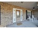 Inviting front porch with brick facade, rocking chairs, and a 'Welcome' mat at 4111 Alayna Lee Cir, Mcdonough, GA 30252