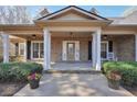 Charming front porch with white columns, brick facade, and colorful flower pots at 4111 Alayna Lee Cir, Mcdonough, GA 30252