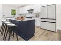 Modern kitchen featuring white cabinets, a navy island with seating, stainless steel appliances, and stylish finishes at 3185 Hammarskjold Dr, East Point, GA 30344