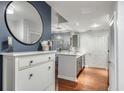 The entryway features stylish decor, including a round mirror, wood floors, and a view into the adjacent kitchen at 1101 Juniper Ne St # 415, Atlanta, GA 30309