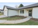 The front of this one-story home featuring a covered porch and well-manicured lawn at 175 Cypress Dr, Covington, GA 30016