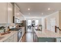 Open kitchen featuring an island with granite countertops, stainless steel appliances, hardwood floors, and recessed lighting at 2042 Clay Rd, Snellville, GA 30078