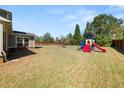 Large backyard featuring a playground with slide and swing set at 2881 Terra View Sw Dr, Lilburn, GA 30047
