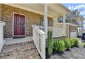 Inviting front porch featuring brick steps, white railing, and lush landscaping leading to a front door at 4349 Northmark Ln, Buford, GA 30518