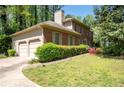 Red brick home featuring an attached two-car garage and mature landscaping at 4140 Westchester Ne Xing, Roswell, GA 30075