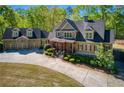 Two-story home with a spacious driveway, a three-car garage, and manicured shrubbery at 1000 Holly St, Canton, GA 30114